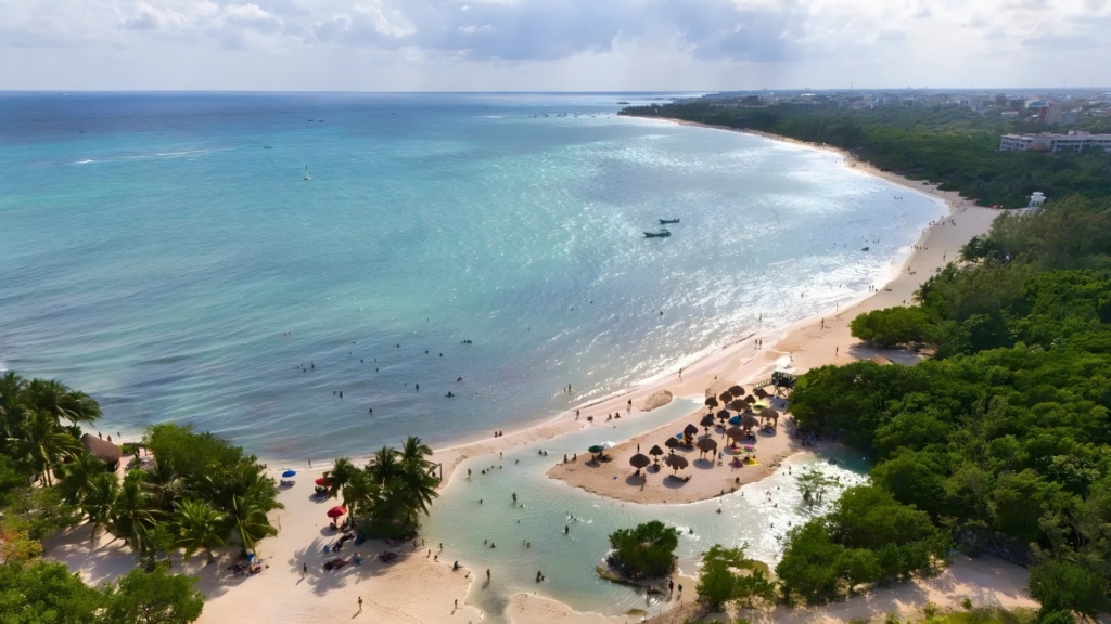 Sunset at Punta Esmeralda beach with calm waters and natural cenote