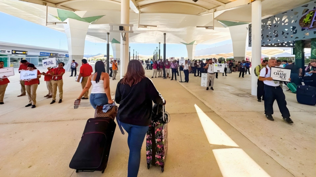 Drivers holding printed signs outside Cancun Airport arrivals.