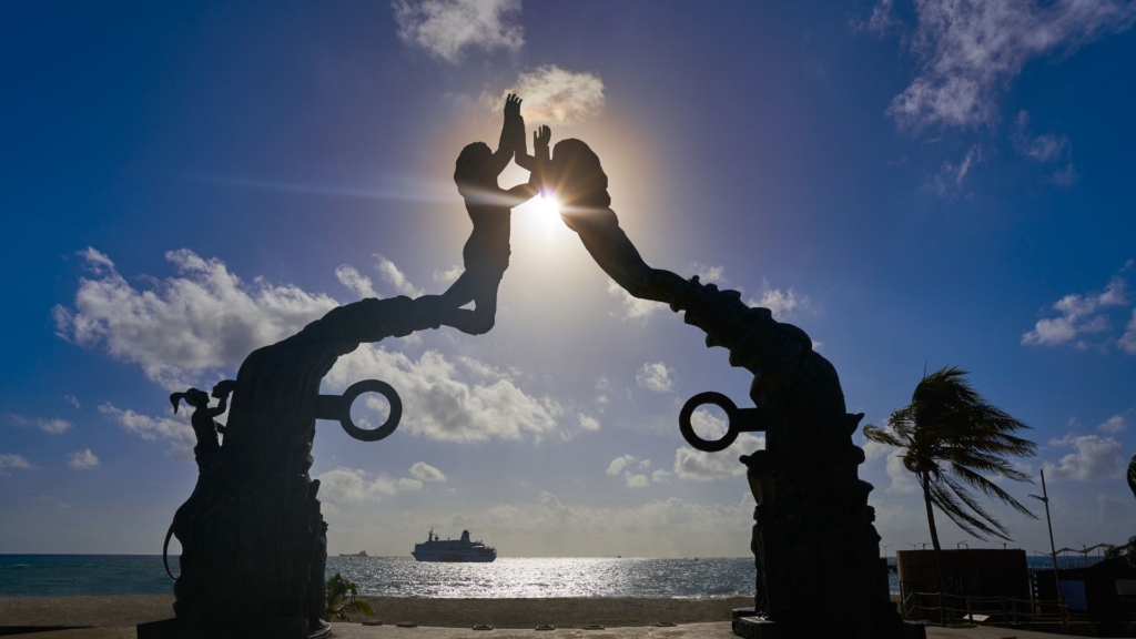 Sunset behind the Portal Maya sculpture in Playa del Carmen.